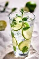 Caipirinha, Mojito cocktail, vodka or soda drink with lime, mint and straw on sand background photo