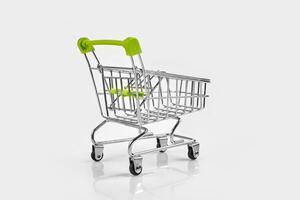 Close up of supermarket grocery push cart for shopping with black wheels on white background. Concept of shopping. photo