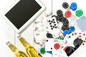 Gambling. Poker chips, cards and the dice nearby tablet on wooden table. Top view. Copyspace. Poker photo