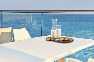 Table for two served with a breakfast on outdoor hotel balcony with a sea view. photo