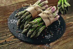 un comestible, crudo tallos de espárragos en un de madera antecedentes. foto