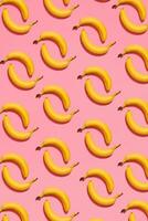 modelo composición de un par de bananas acostado siguiente a un rosado antecedentes , parte superior ver foto