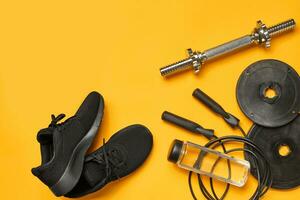 Close-up studio shot of a gym accessories on a yellow background. Top view, flat lay. photo