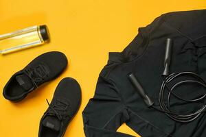 Close-up studio shot of a gym accessories on a yellow background. Top view, flat lay. photo