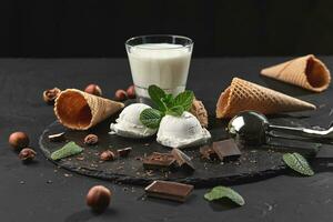 Gourmet creamy and chocolate ice cream served on a stone slate over a black background. photo