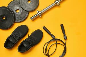 Close-up studio shot of a gym accessories on a yellow background. Top view, flat lay. photo