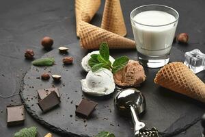 Gourmet creamy and chocolate ice cream served on a stone slate over a black background. photo