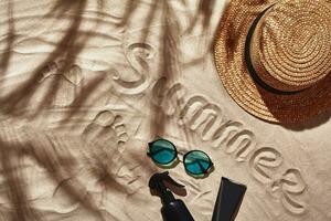 Traveler vacation accessories are laid out on a white beach sand. Flat lay, top view. photo