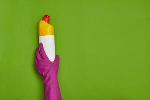 Detergents and cleaning accessories on a green background. Housekeeping concept. photo