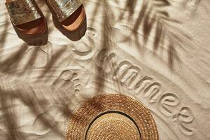 Traveler vacation accessories are laid out on a white beach sand. Flat lay, top view. photo