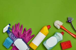 Detergents and cleaning accessories on a green background. Housekeeping concept. photo