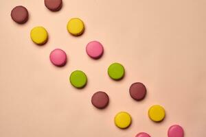 Colored macaron or macaroon, sweet meringue-based confection on pink background. Close-up, copy space. photo