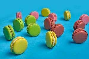 Colored macaron or macaroon, sweet meringue-based confection on blue background. Close-up, copy space. photo