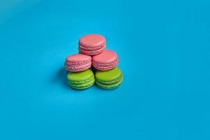 Colored macaron or macaroon, sweet meringue-based confection on blue background. Close-up, copy space. photo