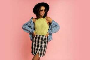 Nice smiling stylish woman in spring outfit posing over pink backgrond in studio. photo