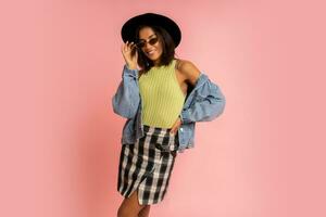 Nice smiling stylish woman in spring outfit posing over pink backgrond in studio. photo