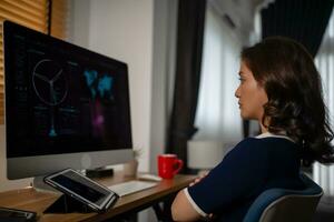 Futuristic women Engineer working with Holographic Augmented Reality and 3D Wind Turbine Model on computer and tablet at home office ,Concept of technology and environment photo