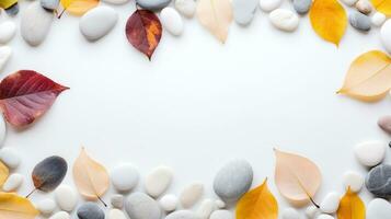 AI Generated A white background with a border of pebbles and autumn leaves The pebbles are smooth and round, in various shades of gray and white The leaves are orange, yellow, and red, and are photo