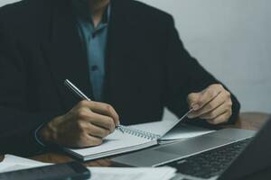 man hands with pen writing journal on notebook in the office.creativity inspiration learning, education and work.writes goals, plans, make to do and wish list on desk. photo