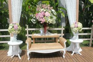 tradicional Boda atmósfera con flor decoraciones en un jardín y al aire libre atmósfera foto