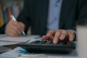 Accountants use calculators to review financial and tax accounting documents. photo