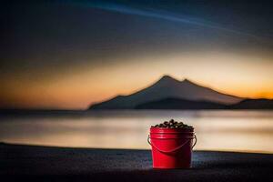 a red bucket on the beach with a mountain in the background. AI-Generated photo