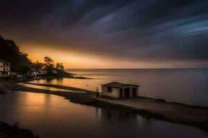 a house sits on the shore of the ocean at sunset. AI-Generated photo