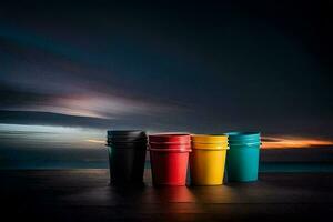 four colorful cups sit on a table in front of the ocean. AI-Generated photo