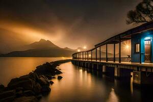 a blue building on a dock at night with mountains in the background. AI-Generated photo