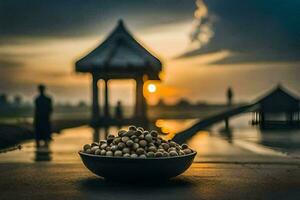 the bowl of peanuts is placed on the ground in front of the sunset. AI-Generated photo