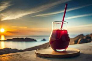 un vaso de jugo con un Paja en un de madera mesa en frente de el océano. generado por ai foto