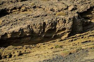 a person is walking on a rocky cliff photo