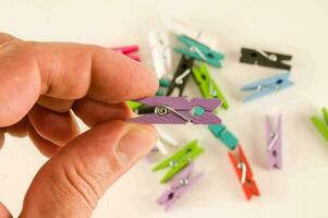 a person holding a small piece of clothes pegs photo