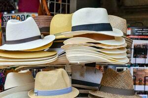 many hats are displayed on a stand in a market photo