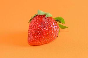 a strawberry on an orange background photo