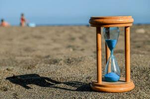 an hourglass on the beach sand photo