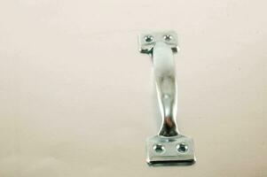 a close up of a metal latch on a white surface photo