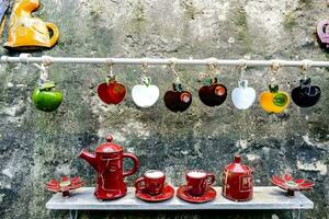 a display of red and green ceramic cups and teapots photo