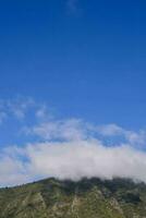 un montaña con un nube terminado eso foto