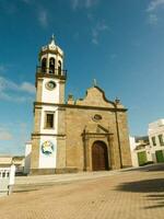 a church with a clock tower in the middle of a town photo