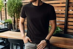 Young man wearing bella canvas black t shirt and jeans, at a cozy restaurant on summers day. Design tshirt template, print presentation mockup. Ai generated. photo