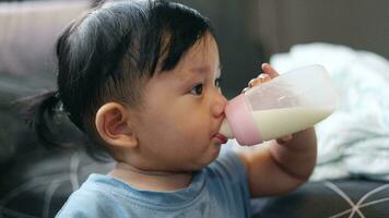 Cute Baby  Holding Bottle And Drinking Milk. Formula Drink For Infant. Close Up video