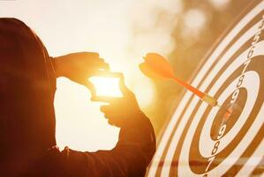 Planning and goals for starting the new year. man's hand gestures focus on search frame, and target board with bright sunshine showing perspective to capture the meaning of the goal approaching. photo