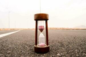 an hourglass sitting on the road photo