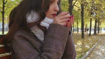 Woman Drinking Hot Beverage in Park video