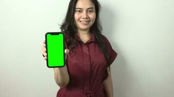 Woman holding phone green screen video