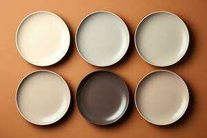 A chic set of minimalistic porcelain dining plates isolated on a taupe gradient background photo