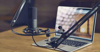 Home studio for an audio podcast host. Studio microphone and laptop on the table video