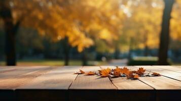Wooden table with a background of an autumn park and falling leaves photo