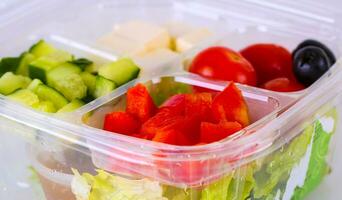 chopped vegetables for Greek salad in a plastic bowl photo